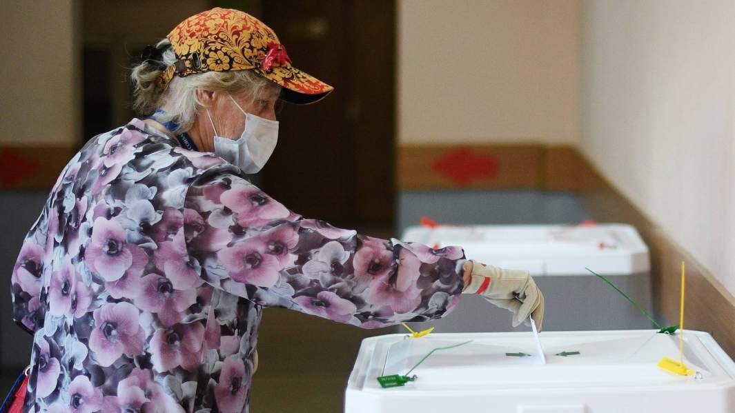 Женщина голосует на избирательном участке