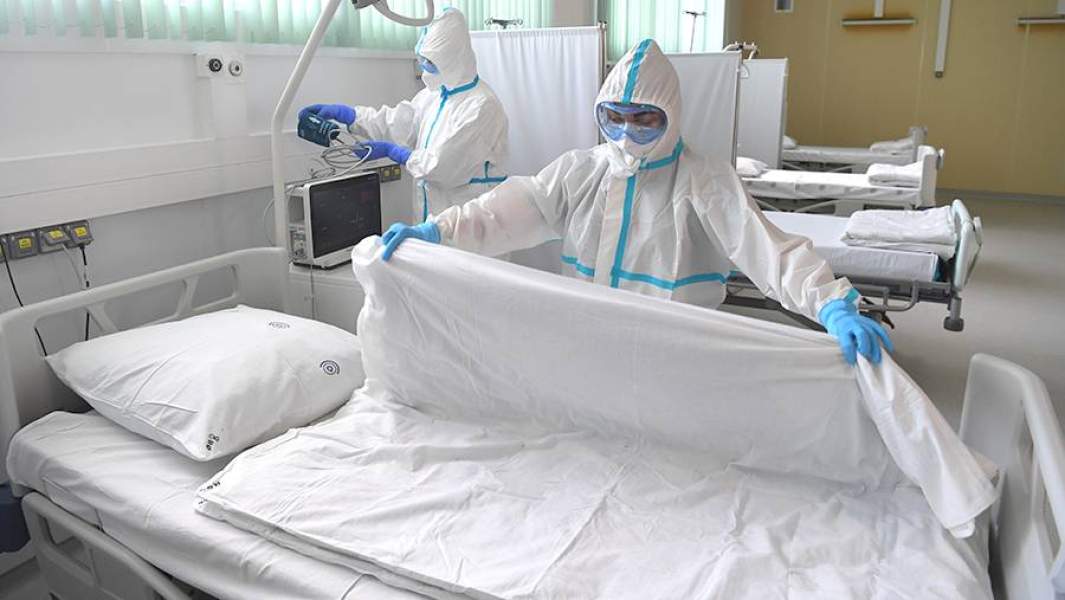 Медицинские работники готовят койку в отделении реанимации больницы