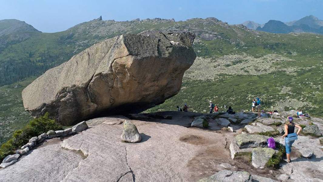 Туристы у висячего камня на территории природного парка Ергаки