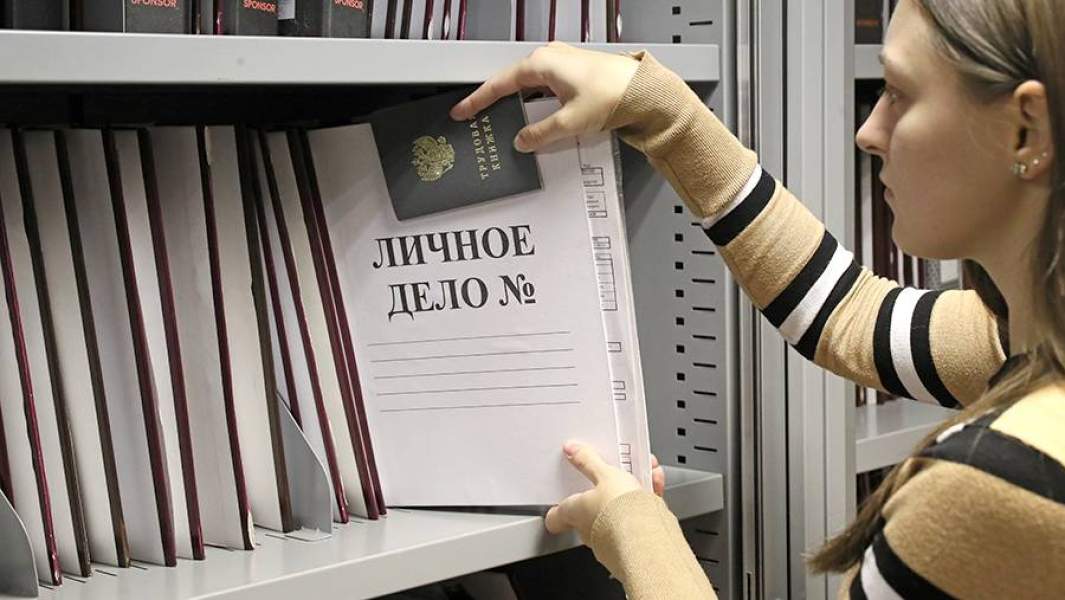 Сотрудница отдела кадров с папкой личного дела и трудовой книжкой