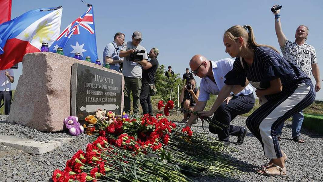 Люди несут цветы к памятнику жертвам авиакатастрофы самолета Boeing-777 компании «Малайзийские авиалинии»