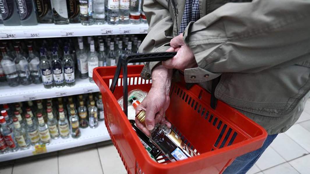 Мужчина в вино-водочном отделе супермаркета