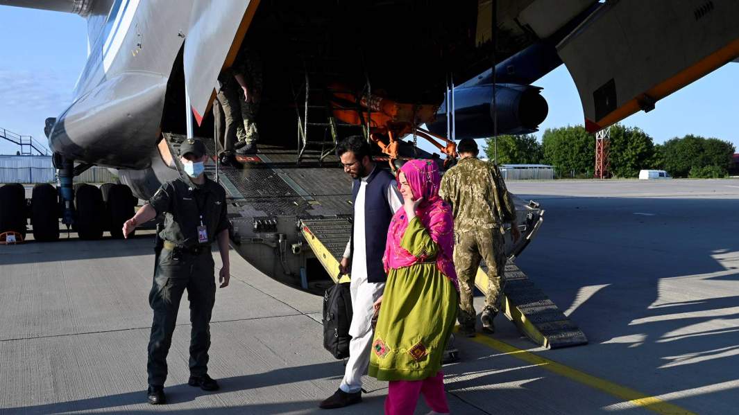Люди, эвакуированные из Афганистана, выходят из украинского военного самолета в международном аэропорту Борисполь под Киевом, Украина, 22 августа 2021