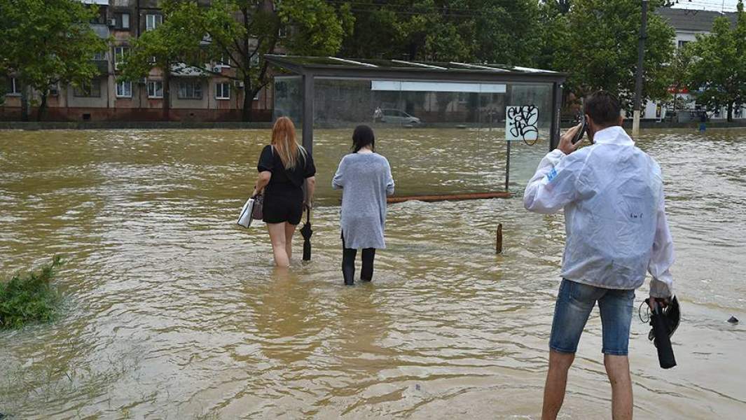 Прохожие на подтопленной в результате ливневых дождей улице в Керчи