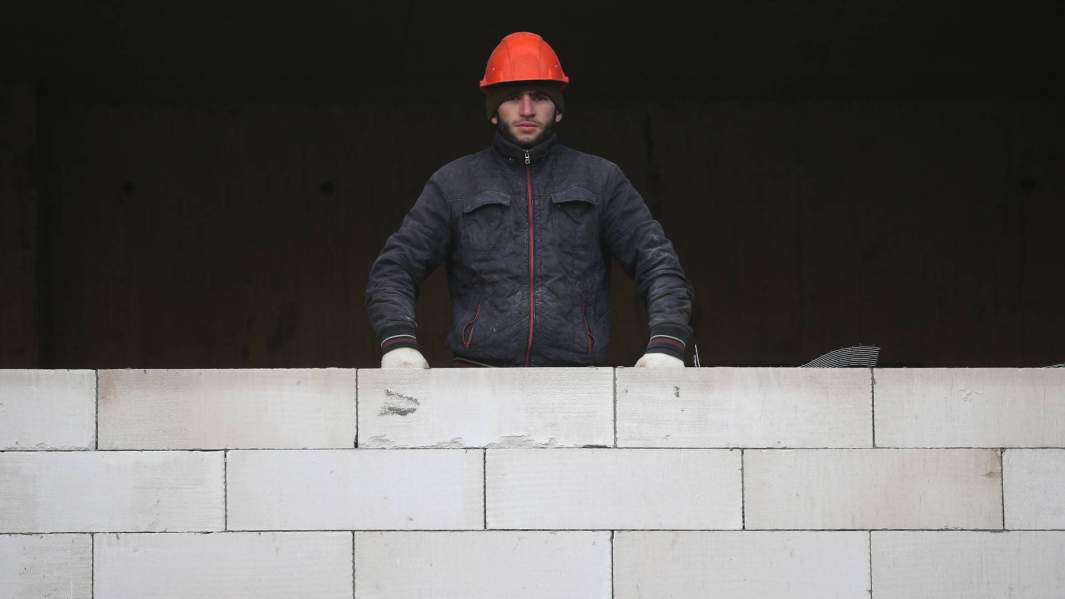 Мигрант-строитель на стройке