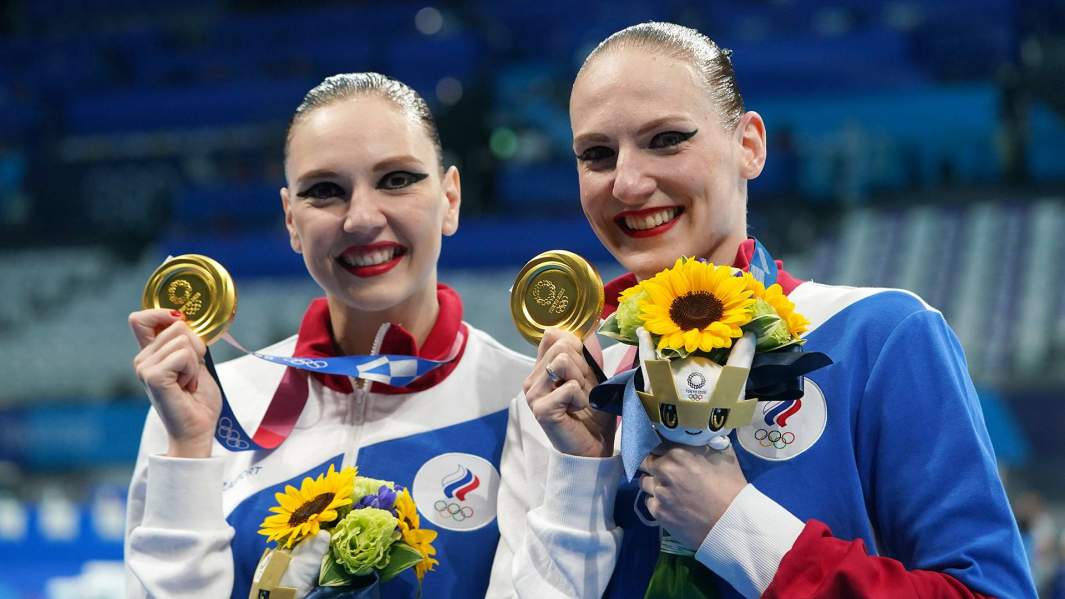 Российские спортсменки (команда ОКР) Светлана Колесниченко и Светлана Ромашина (справа), завоевавшие золотые медали с произвольной программой в соревнованиях по синхронному плаванию дуэтов на XXXII летних Олимпийских играх в Токио, на церемонии награждения