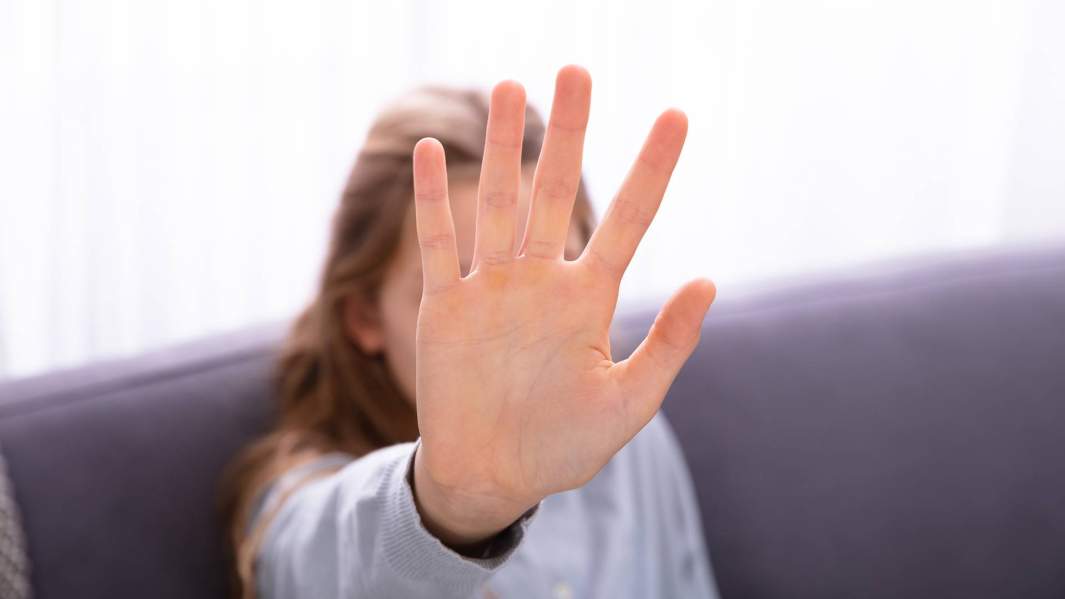 девочка закрывает лицо рукой