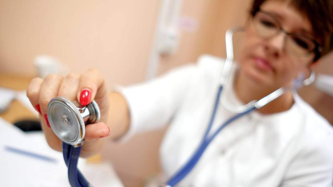 Врач одной из поликлиник Краснодара в кабинете во время осмотра перед вакцинацией против гриппа