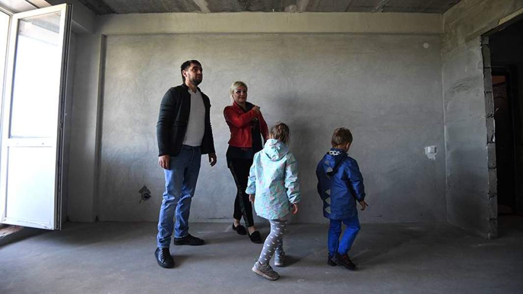 Семья осматривает квартиру нового дома, построенного в Новосибирске