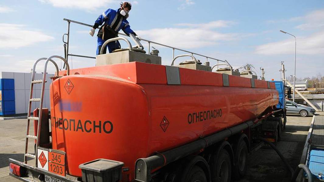 Оператор автозаправочной станции в Челябинской области проверяет сохранность пломб на цистерне бензовоза перед сливом топлива в емкости