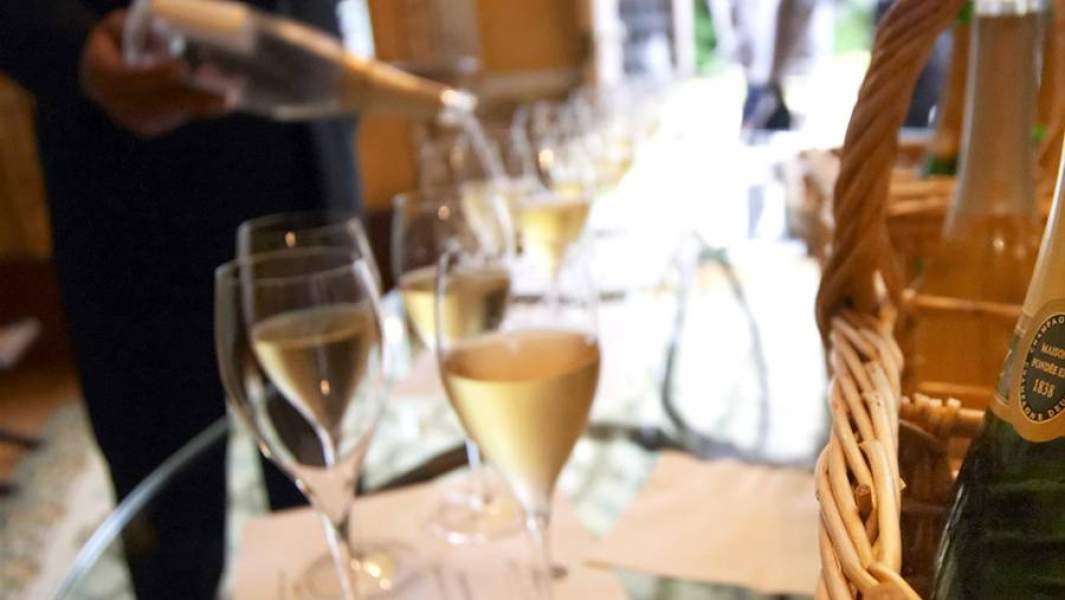 Мужчина разливает шампанское по бокалам