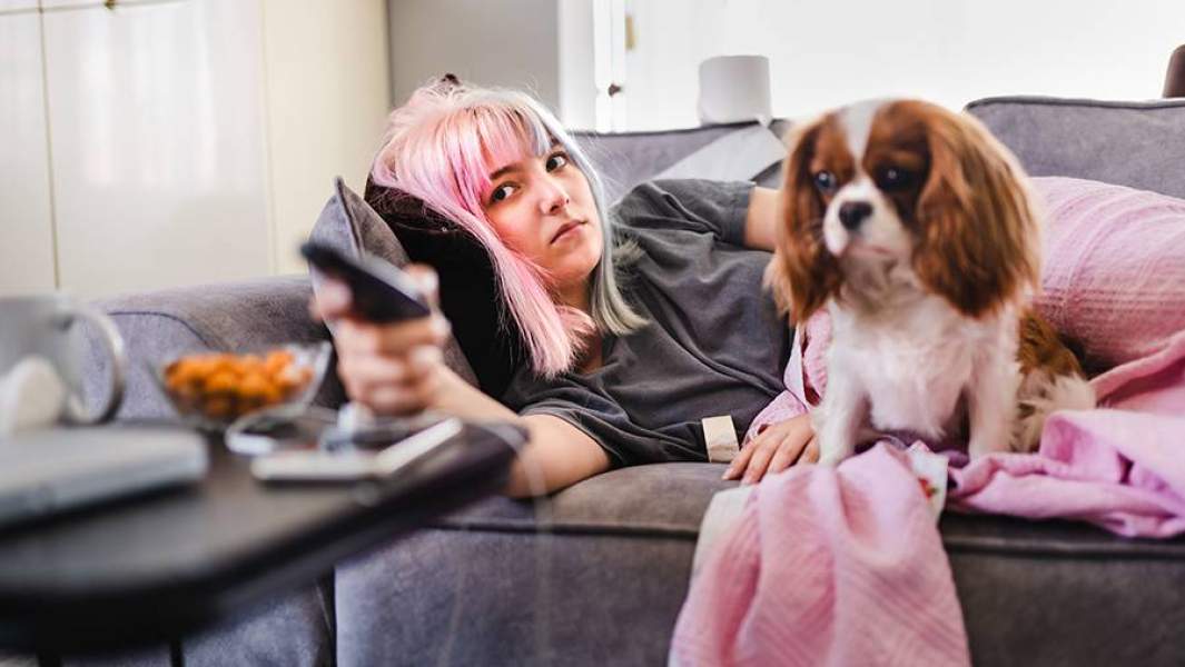 Безработная женщина на диване перед телевизором