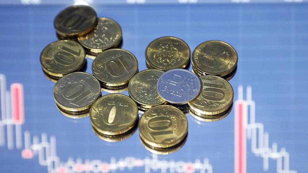 Монеты рубли на фоне графиков