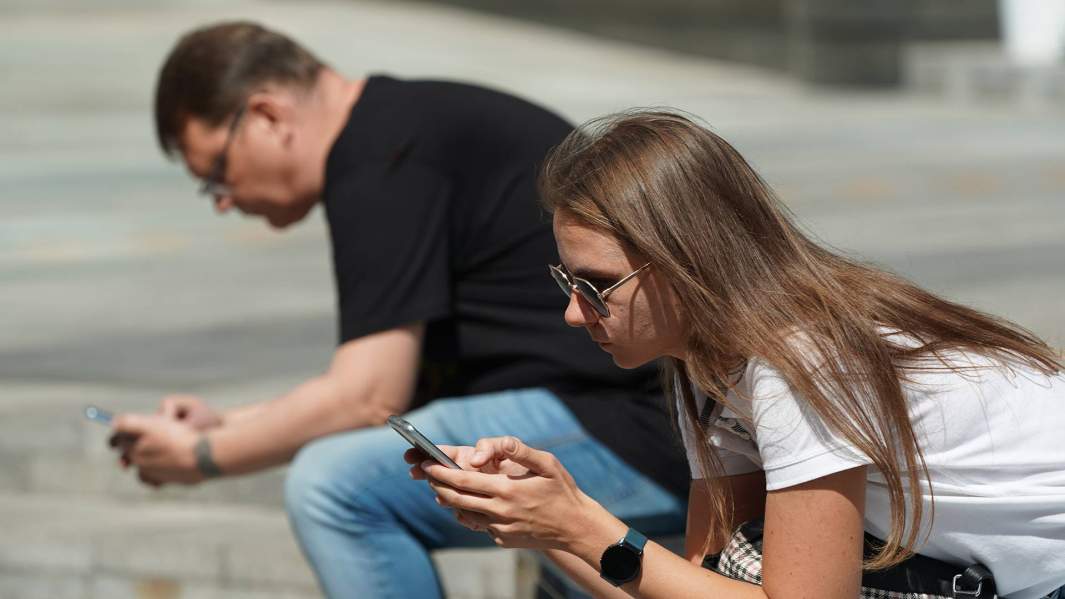 молодые люди с телефонами в руках