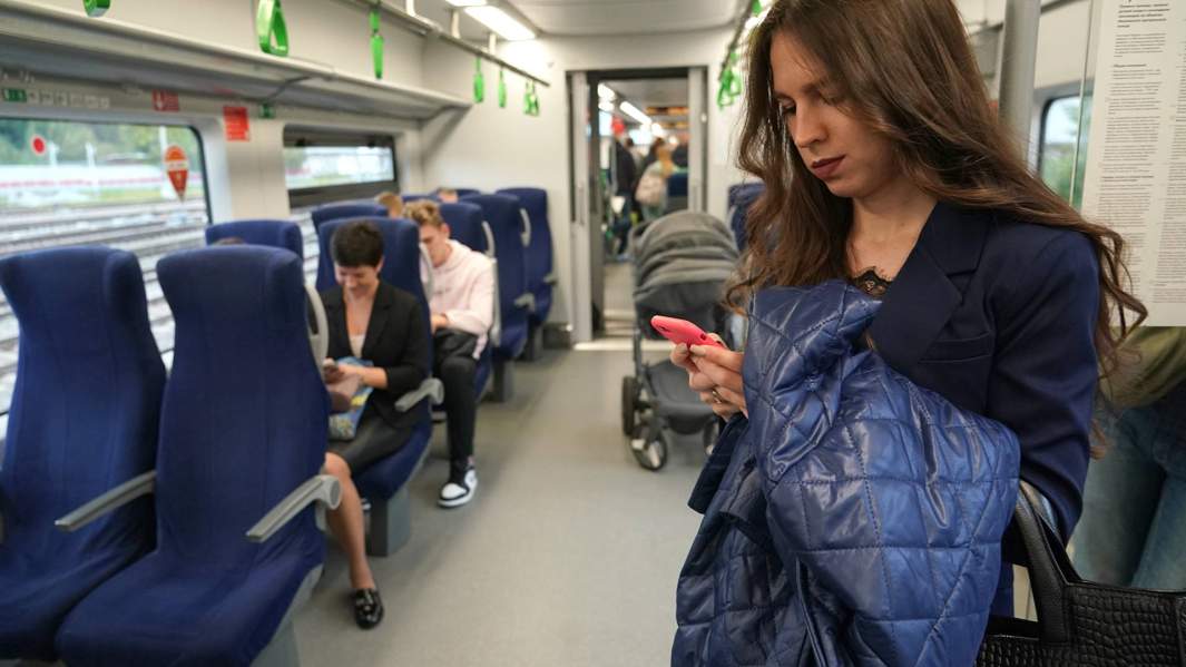 Женщина со смартфоном в вагоне поезда