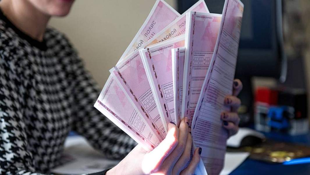 Сотрудник страховой компании демонстрирует страховой полис ОСАГО