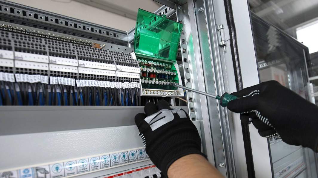 Рабочий во время сборки систем автоматизации "Умный дом"