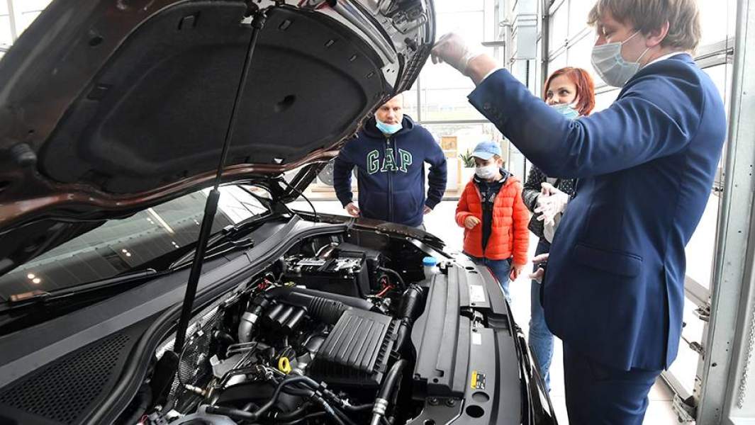 Посетители автосалона в Москве осматривают автомобиль