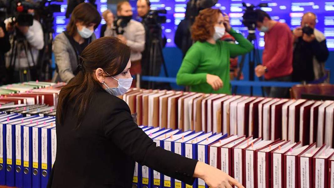 Сотрудники Центральной избирательной комиссии РФ выкладывают папки с итоговыми протоколами региональных избирательных комиссий по общим результатам выборов депутатов в Государственную Думу РФ 8-го созыва