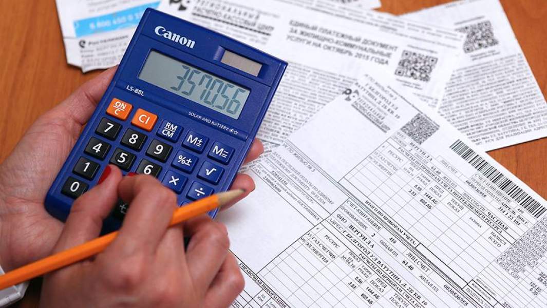 Женщина заполняет квитанции на оплату коммунальных услуг