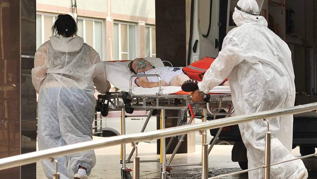 Медицинские сотрудники с пациентом у приемного отделения госпиталя на базе Краевой клинической больницы