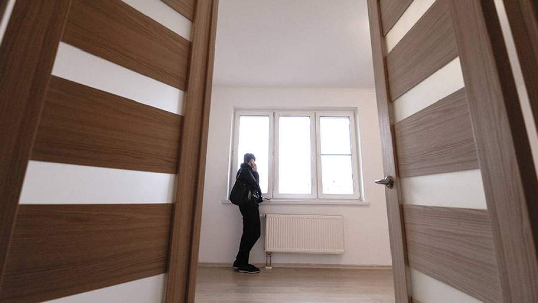 Молодой человек в комнате новостройки