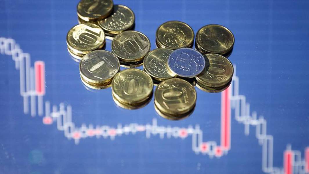 Монеты рубли на фоне графиков