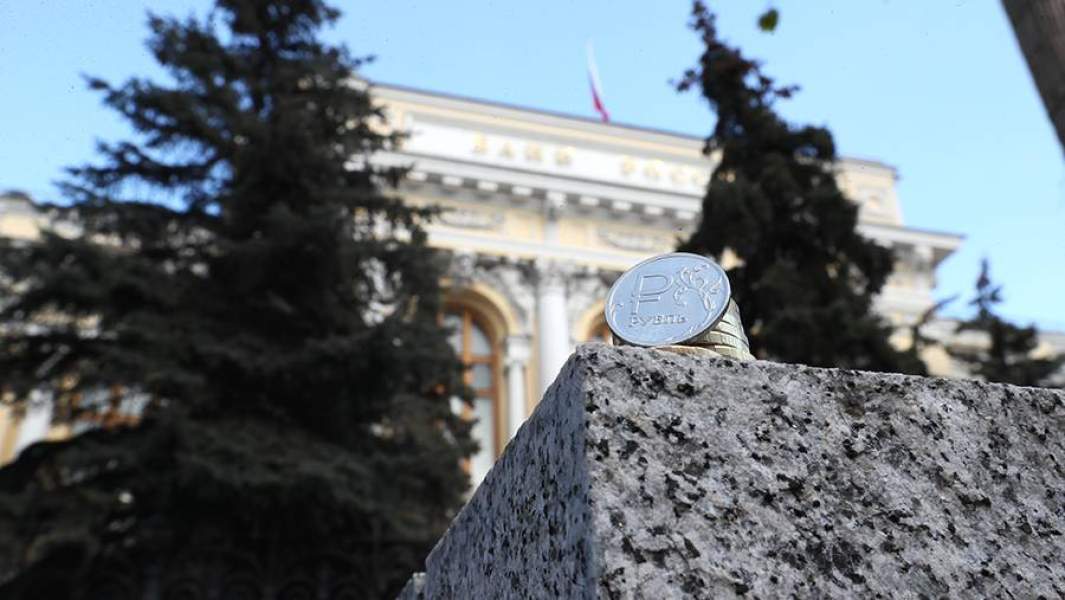 Монета рубль на фоне здания ЦБ РФ