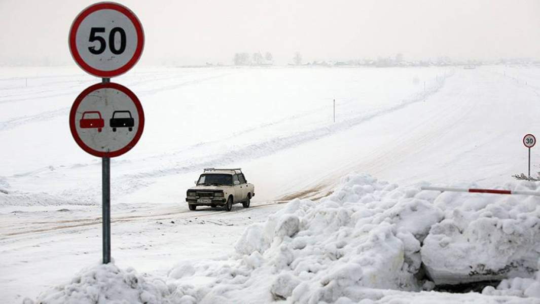 Автомобиль проезжает по ледовой переправе Спирино — Чингисы через водохранилище Новосибирской ГЭС на реке Обь в Новосибирской области