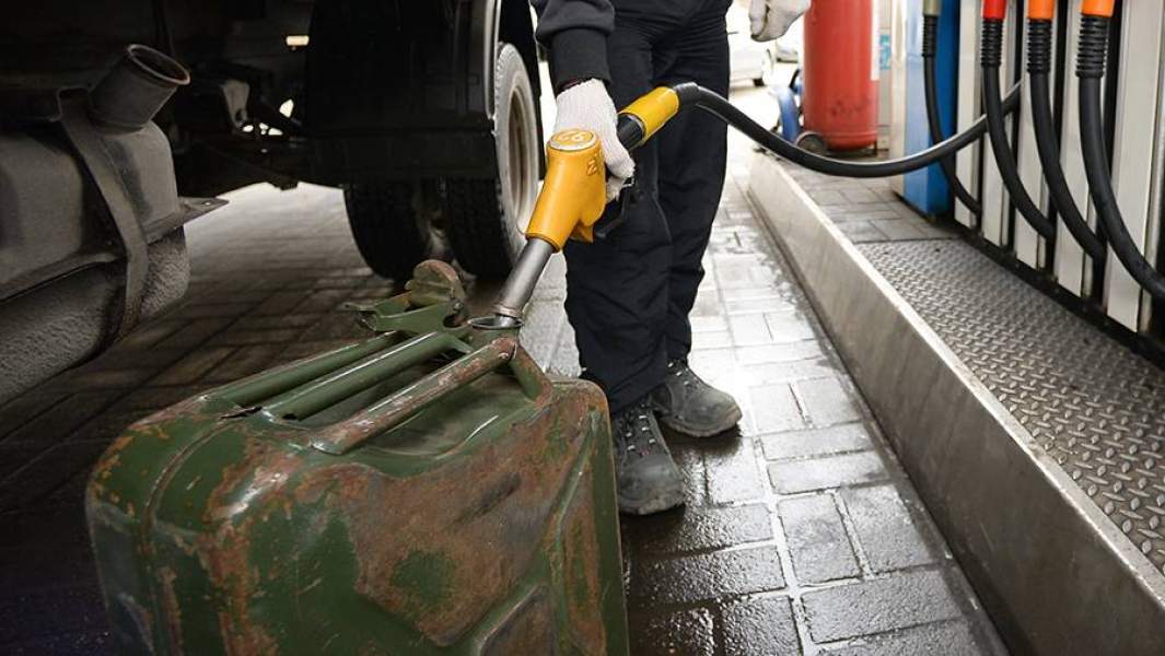 Мужчина заправляет канистру на автозаправочной станции