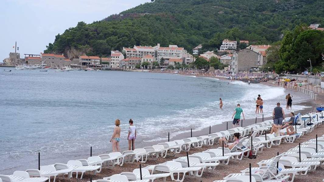 Отдыхающие на пляже в Петроваце в Черногории