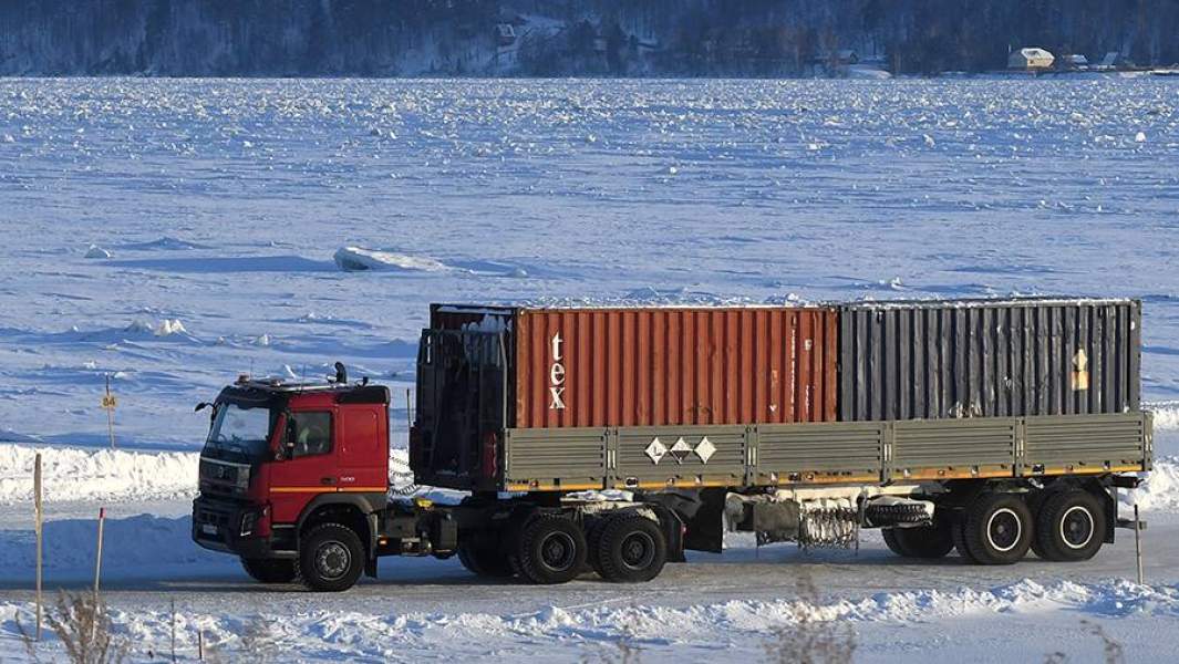 Грузовик с контейнерами едет по ледовой переправе через Енисей