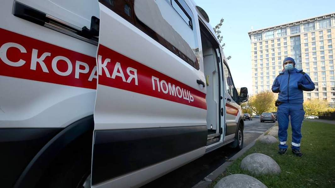 Машина скорой медицинской помощи и медицинский сотрудник на территории Городской Покровской больницы