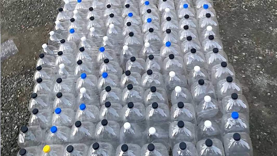 Бутылки со спиртосодержащей жидкостью, изъятые следователями во время обнаружения склада и пункта производства контрафактного алкоголя