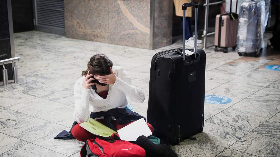 Пассажир пытается найти рейс, так как несколько авиакомпаний перестали вылетать из Южной Африки в связи с распространением нового варианта SARS-CoV-2 Omicron в O.R. Международный аэропорт Тамбо в Йоханнесбурге, ЮАР