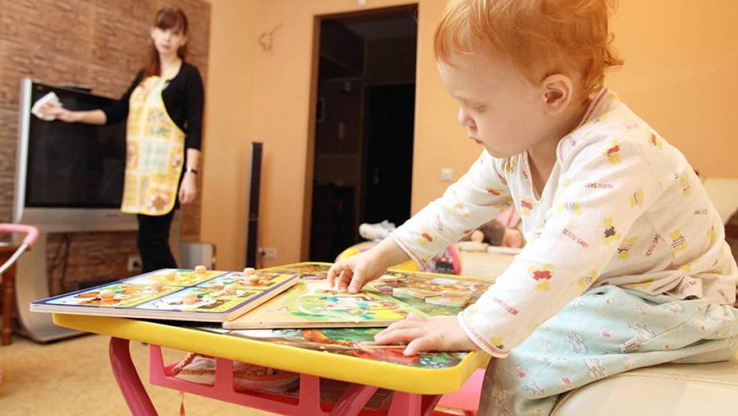Няня наблюдает за ребенком во время уборки дома