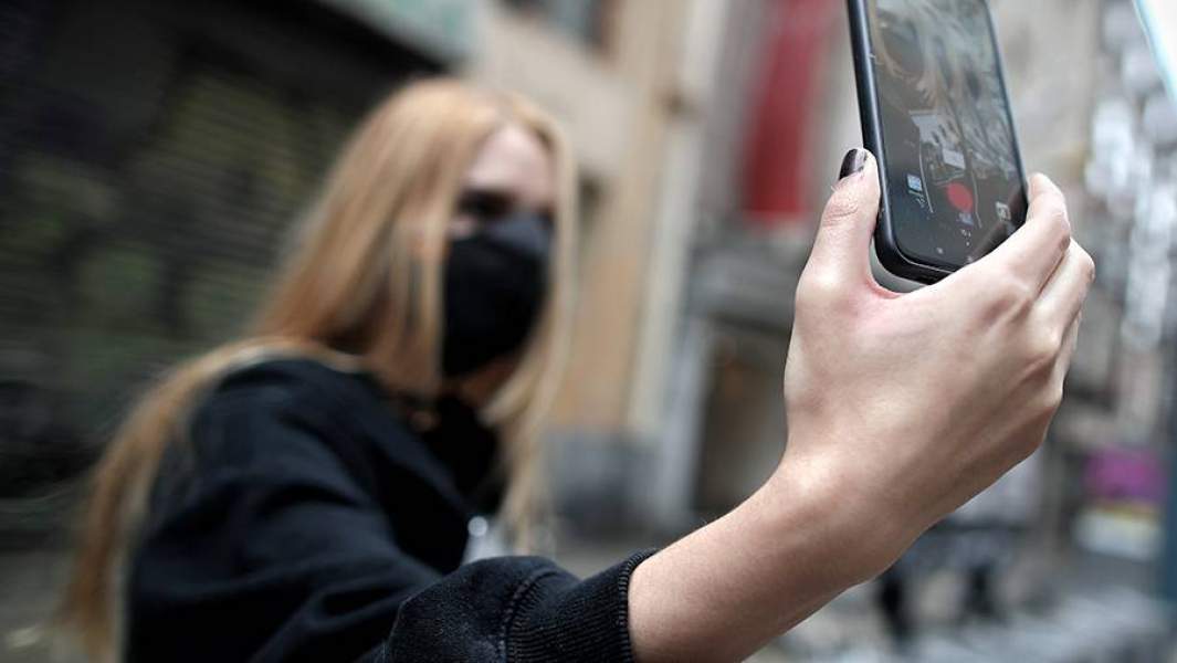 Девушка в черной маске снимает ролики для соцсети