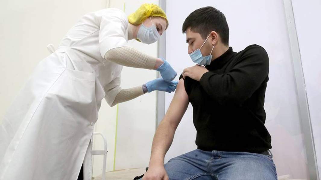 Медсестра во время вакцинации пациента для профилактики коронавирусной инфекции COVID-19 в центре вакцинации в торговом центре