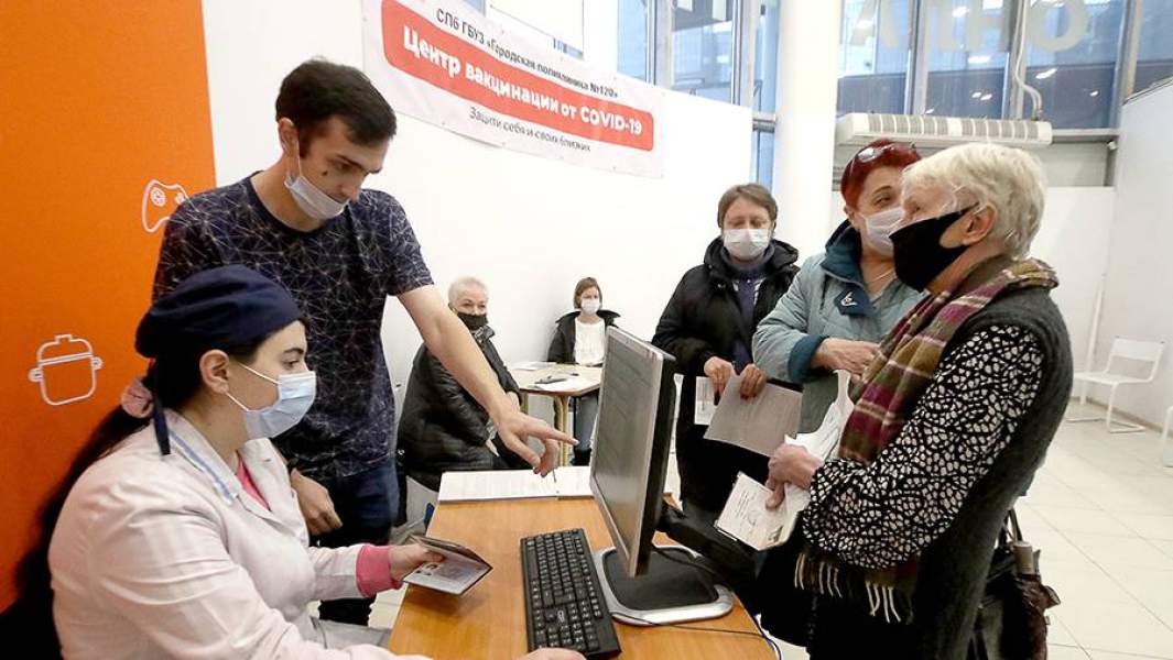 Медсестра и пациенты перед вакцинацией для профилактики коронавирусной инфекции COVID-19 в центре вакцинации в торговом центре