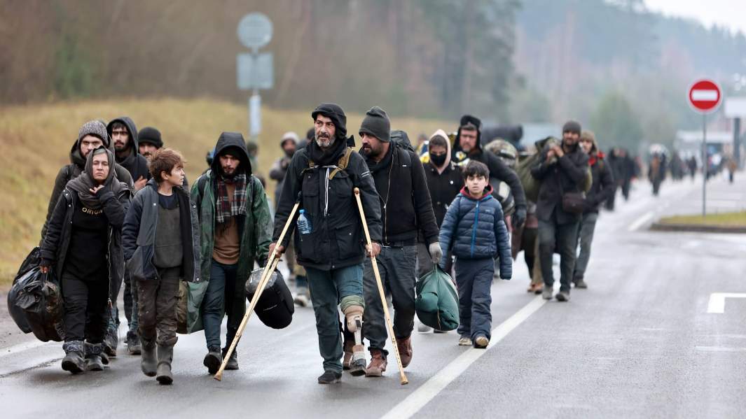 Беженцы с Ближнего Востока идут в центр временного содержания мигрантов, оборудованный в логистическом центре в пункте пропуска «Брузги» на белорусско-польской границе