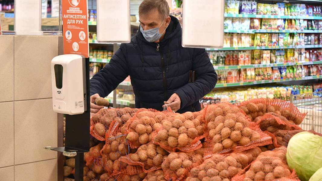 Мужчина покупает картошку