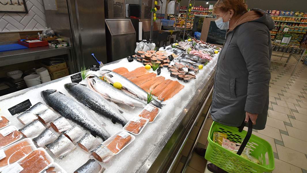 Женщина в рыбном отделе продуктового магазина