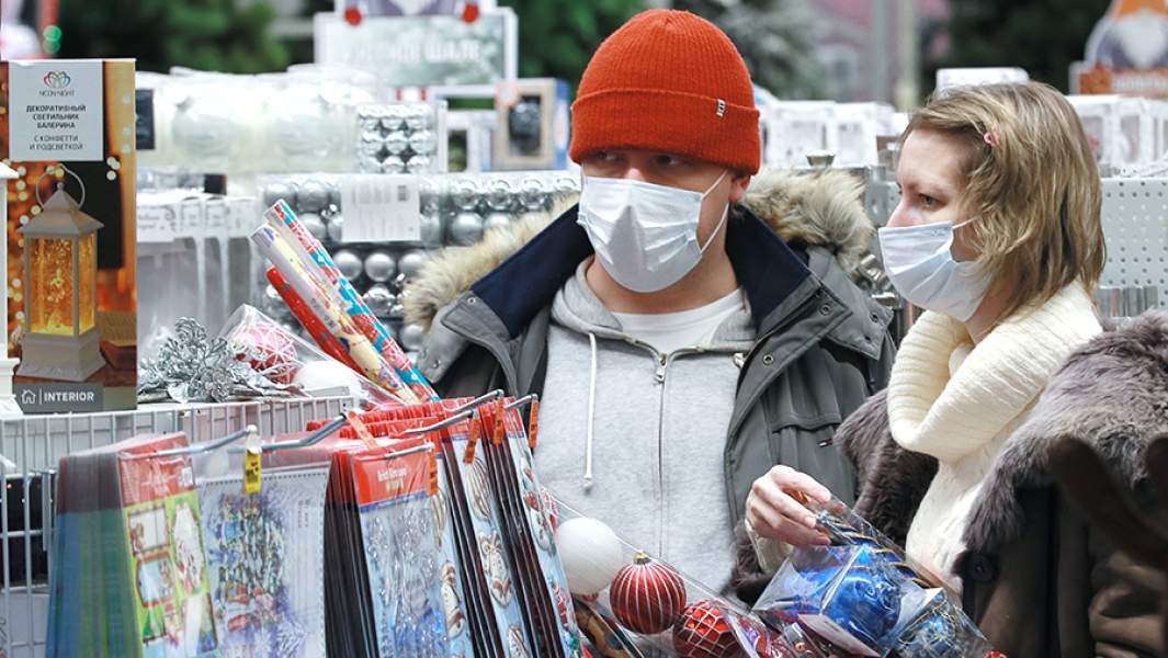 Молодые люди выбирают елочные украшения в магазине