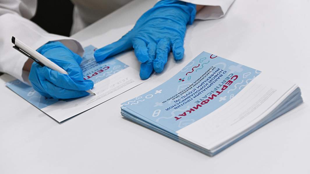 Медицинский сотрудник подписывает сертификат в центре вакцинации