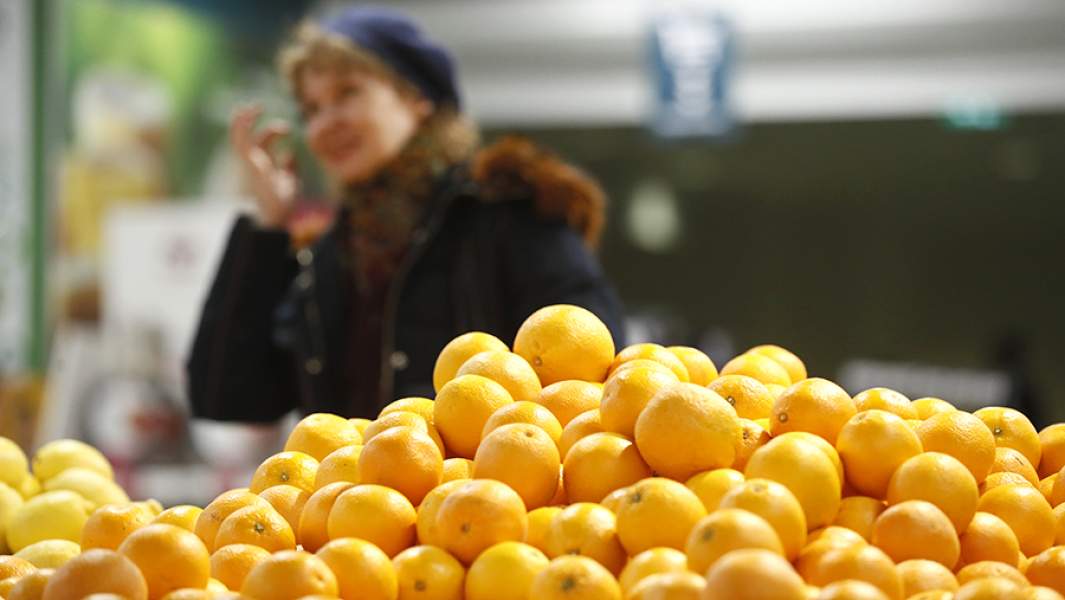 Женщина у прилавка с мандаринами