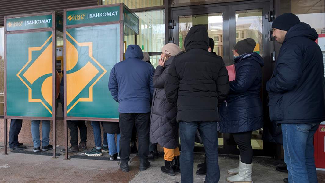 Местные жители стоят в очереди у одного из банкоматов в Нур-Султане
