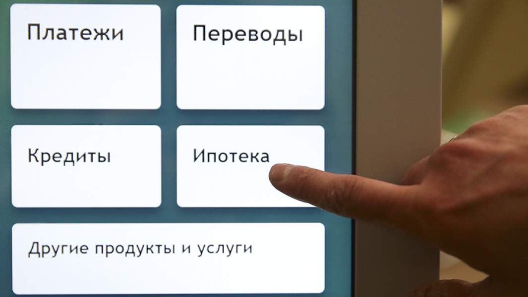 Посетитель банка у терминала с перечнем услуг в одном из отделений