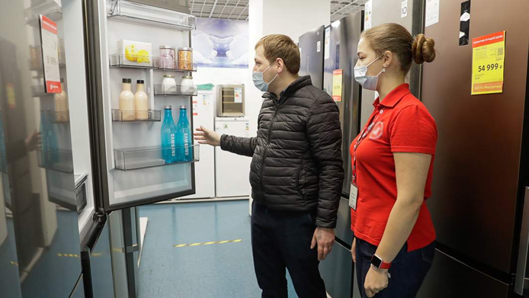 Покупатель выбирает холодильник в магазине