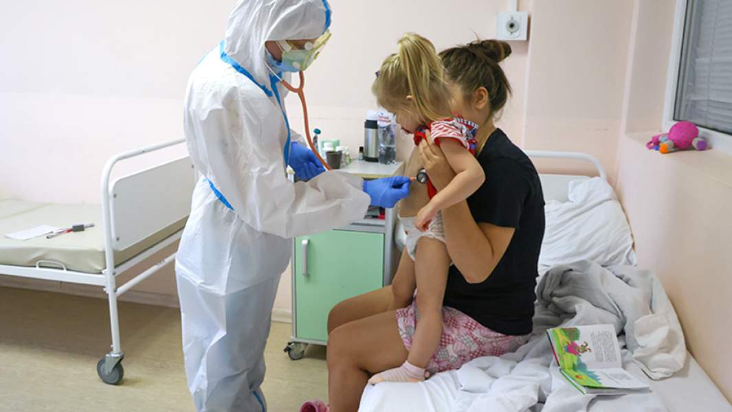 Медработник и пациентка с ребенком в красной зоне детской городской клинической больницы