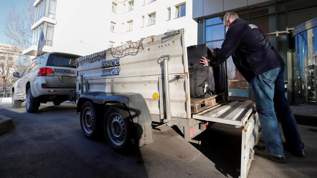 Член Организации по безопасности и сотрудничеству в Европе (ОБСЕ) загружает багаж перед тем, как покинуть отель Park Inn, в котором находится наблюдательная миссия в подконтрольном повстанцам городе Донецке, Украина, 13 февраля.